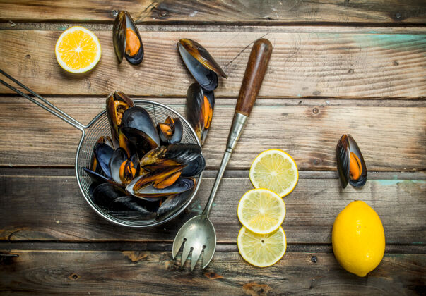 木材新鲜的海鲜蛤蜊和柠檬楔放在乡村的桌子上海洋美食平底锅