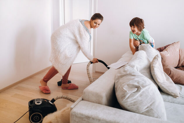 设备妈妈在家用吸尘器打扫地板 儿子看着笑着说电地板房间
