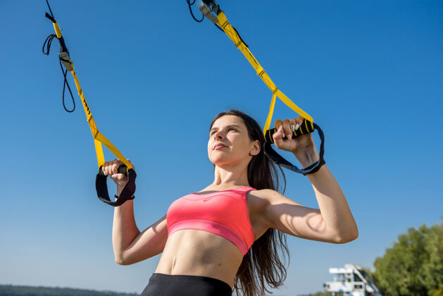 耐力白天在湖边用吊带在户外锻炼的美女健康的生活方式女性湖泊运动