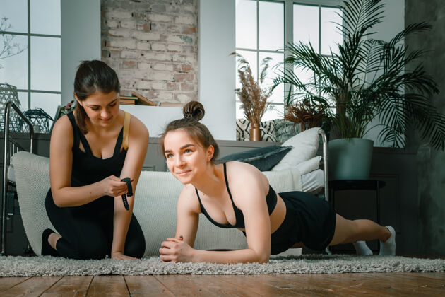健身房年轻女性在家里运动 在线训练运动装健康力量