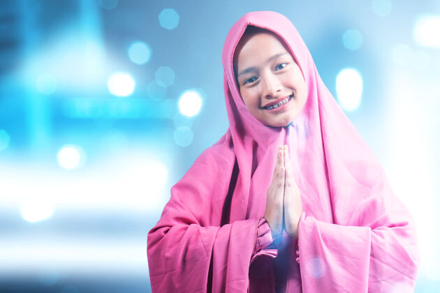 神圣戴面纱的亚洲妇女 用模糊的灯光背景打招呼阿拉伯语菲律宾模糊
