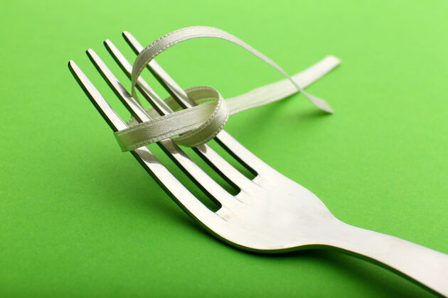 设置在绿色的桌子上用叉子绑弓的阶段 特写镜头设备餐具餐具