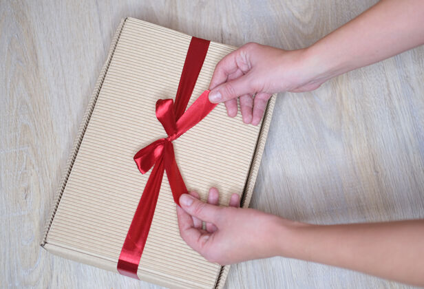 爱女性手特写 拿着一个红色丝带盒子里的礼物浪漫礼物一天