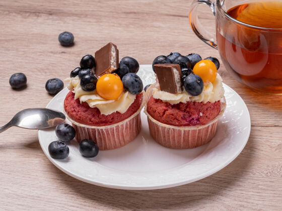 甜点美味的水果松饼配浆果和巧克力 放在一个白色盘子里 还有一个圆形的杯子茶自制的在木桌上吃早餐食物美味自制食物