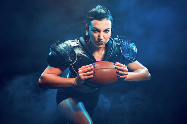 坐着穿着性感制服的年轻黑发橄榄球运动员与球合影模型性感衣服