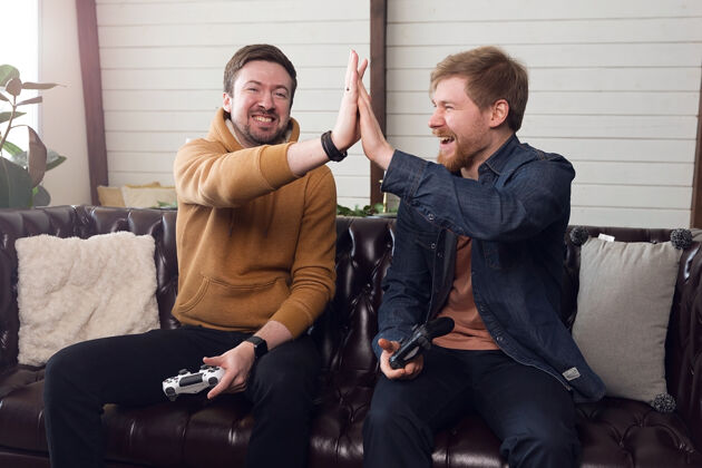 男性两个朋友在玩游戏机 游戏和娱乐家高高质量的照片室内房子小组