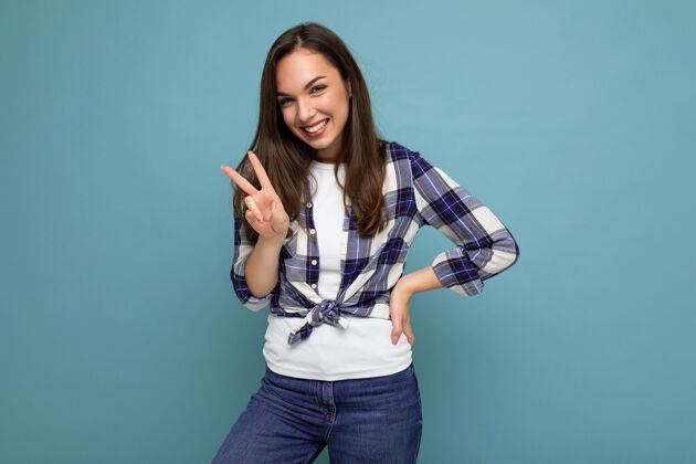年轻年轻积极快乐微笑美丽的深褐色女士 带着真诚的情感 穿着格子衬衫 披着蓝色的外衣和平人格子衬衫