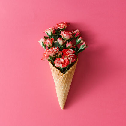 植物粉红色表面有彩色花朵的冰淇淋筒开花花开花