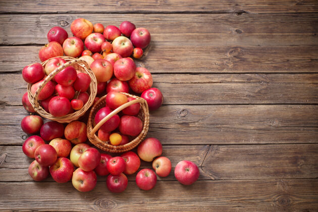 红色老木头背景上的红苹果篮子吃农作物