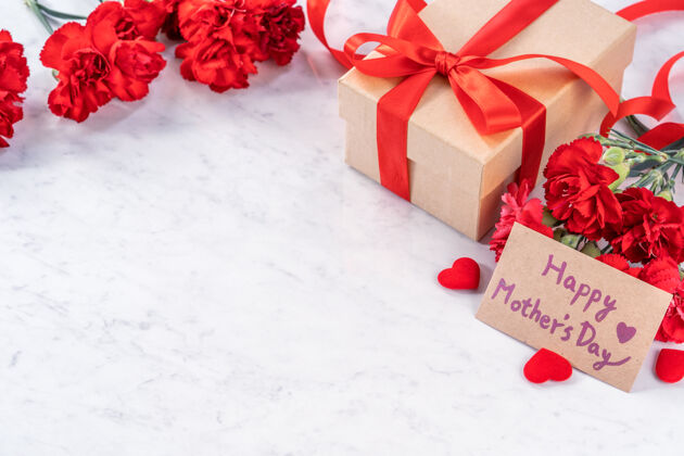 消息一束红色康乃馨配礼盒 为母亲节的问候概念束心空白