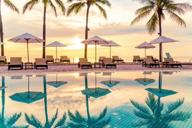 户外酒店度假村游泳池周围的雨伞和椅子早上假期还有度假的概念无限棕榈椰子