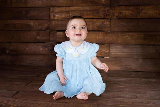 时尚在木制背景上穿着蓝色裙子的漂亮女孩小情感年轻