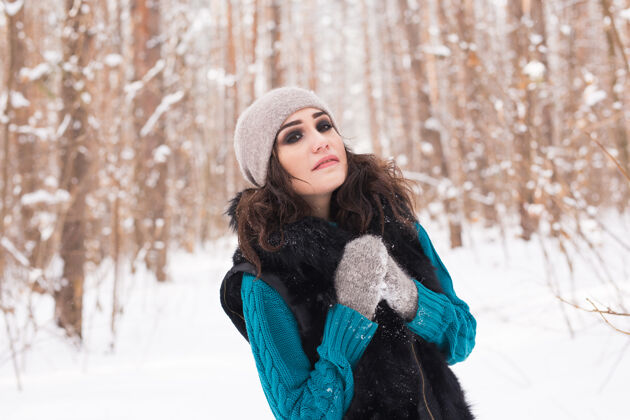 女性在阳光明媚的日子里 年轻漂亮的女人在冬天的雪地公园里散步柔软明亮季节