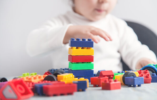 积木小女孩在玩五颜六色的建筑塑料块发展建筑创意