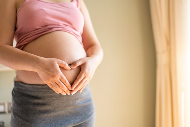 妈妈怀着孩子的快乐孕妇腹部产妇产前护理和妇女怀孕健康母亲健康怀孕
