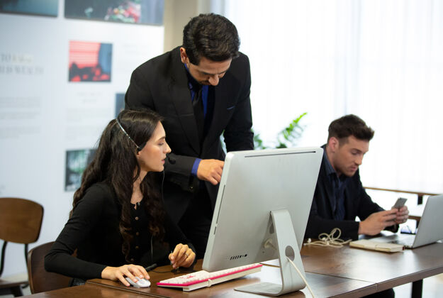 会议商务人士在办公室使用数字平板电脑和电脑交谈会议室内经理