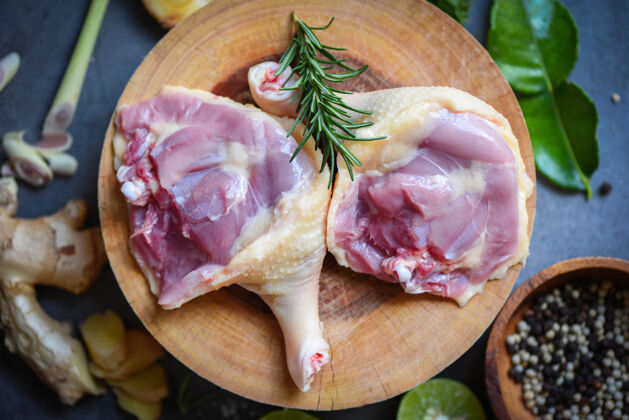 美食生鸭腿配香草调料 可在木砧板上烹调 鲜鸭肉为食生的膳食烹饪