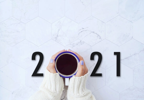 毛衣开始新的一年2021年的概念 顶视图的妇女手中拿着一杯热咖啡的白色大理石背景 目标和计划的动机动机温暖开始