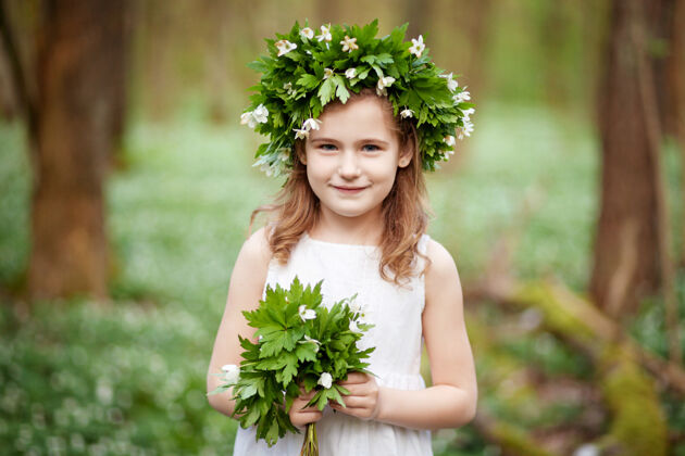 森林春天穿着白裙子的漂亮小女孩伍德肖像画美丽的小女孩头上戴着春花的花环花欢呼公园