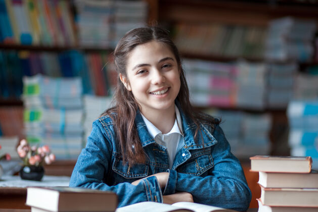 青年漂亮的女学生坐在图书馆看书知识学校书房