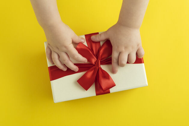 礼物孩子们用手解开礼物上的蝴蝶结机顶盒查看邮件蝴蝶结包装