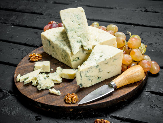 午餐蓝色奶酪放在木板上葡萄.on黑色乡村背景霉菌奶酪食品