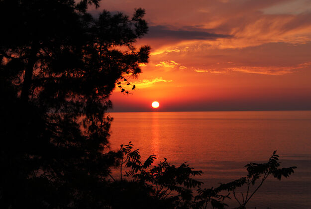 液体美丽的日落在黑海的佐治亚州 地平线和五颜六色天空橙色还有红色阳光日落海岸线