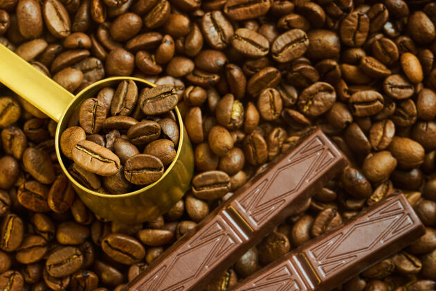 丰盛咖啡豆放在量匙里 巧克力放在刚烤好的咖啡表面香气经典豆类