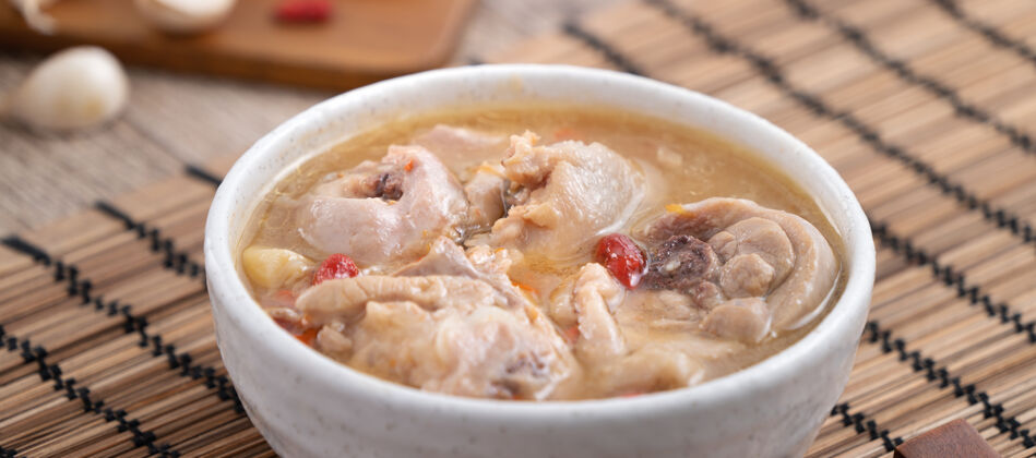 传统台湾菜-自制美味的蒜味鸡汤放在一个碗里 背景是深色的木桌大蒜菜自制