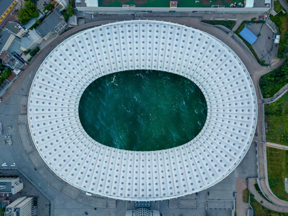 基础设施鸟瞰足球场的无人机全景 里面是海洋绿松石色的水屋顶查看海浪干净无人机