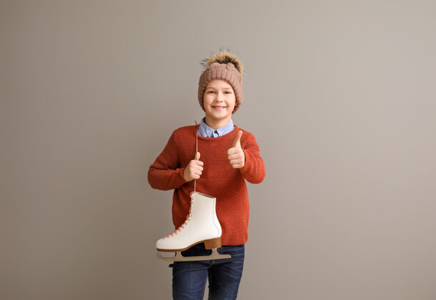 温暖可爱的小男孩 穿着溜冰鞋 拇指朝上抵着灰色溜冰鞋爱好