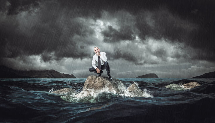 忧虑在波涛汹涌的大海中 一个体贴的人站在岩石上风暴概念工作中的逆境和问题海洋自然冒险
