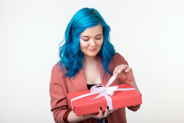 五颜六色人 节日和时尚的概念-快乐的年轻女子蓝色头发手持一个白色背景礼盒室内脸年轻