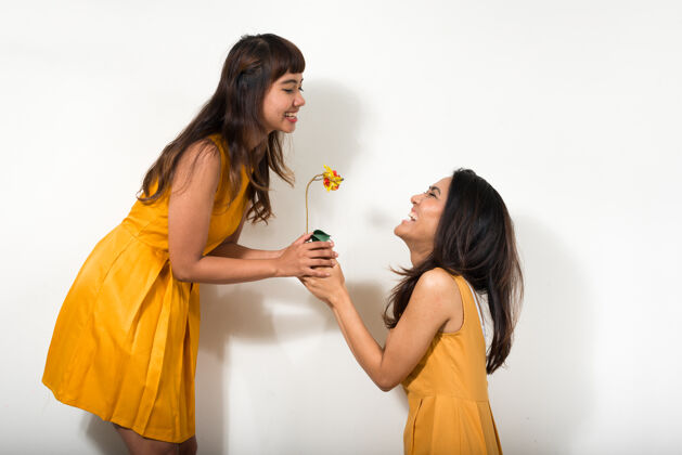 浪漫两个年轻的亚洲女人一起对抗白色空间爱礼物亚洲