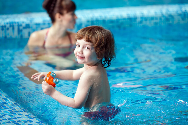 减肥妈妈教孩子在游泳池里游泳宝宝幼儿眼镜