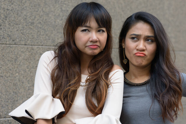爱情两位年轻的亚洲女商人在城市户外的合影泰国道路沮丧