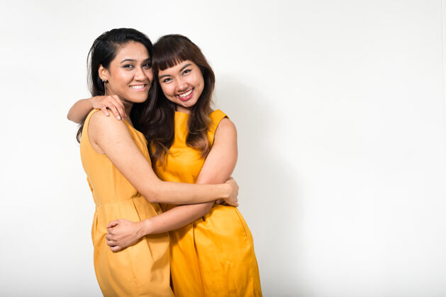 女性两个年轻的亚洲女人一起对抗白色空间同性恋情侣一起