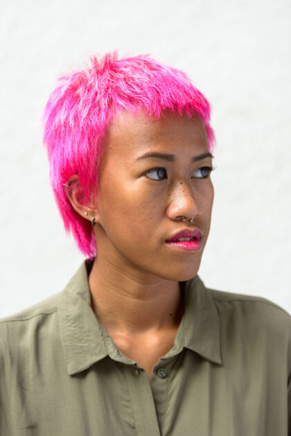 东南年轻叛逆的亚洲女人的肖像 粉色的头发映衬着白色的空间女士朋克女性