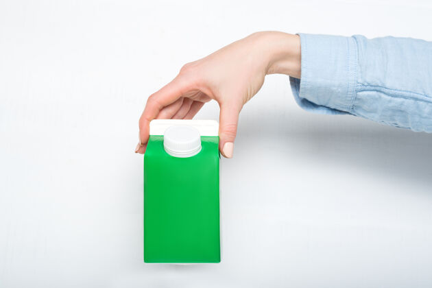 包装绿色纸箱或四联包装 内有盖子手白色背景展示单牛奶