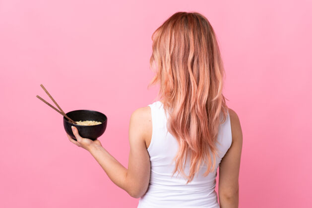 面条女孩就孤零零地站在粉红色的背上 一边用筷子端着一碗面条女人墙俄罗斯