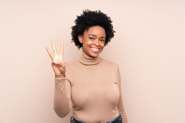 年轻非洲裔美国妇女快乐地用手指数着三个非洲人年轻