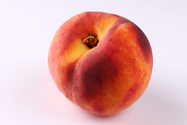 素食白色表面上的一个桃子特写多汁的桃子水果
