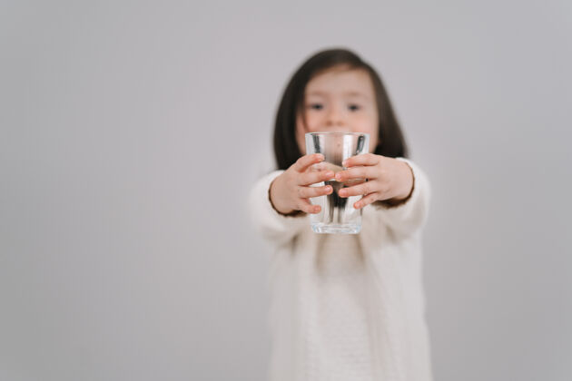 玻璃孩子手里拿着一杯咖啡水水女孩想喝水无辜快乐休闲