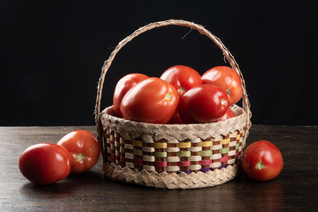 木头篮子里的红番茄和黑桌子乡村食物有机