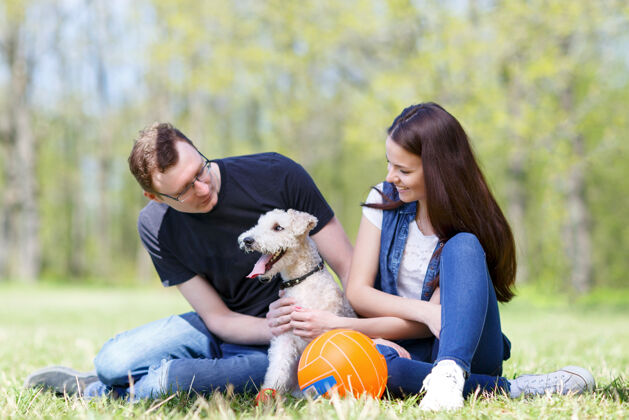 父母快乐的年轻夫妇和他们的狗在公园里可爱男人英俊