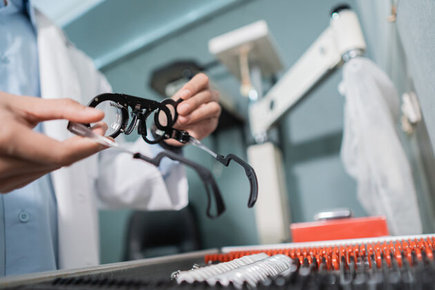 阅读眼科医生的手正在眼科诊所的一个装有一套镜片的盒子里拿一个测试眼镜镜片的量表金属眼科修理