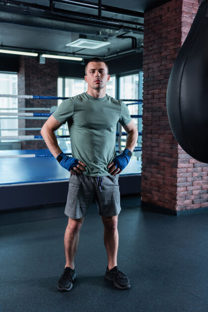 搏斗现代健身房强壮的著名肌肉男站在宽敞的现代健身房里 一边刻苦训练女性运动健身房