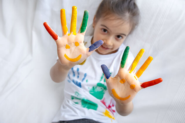 顶视图一个小女孩的手掌上画着微笑女孩有趣孩子们手心上的亮丽图画污渍凌乱玩