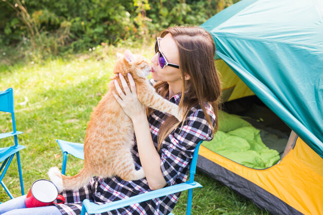 皮带人 夏季旅游和自然的概念-年轻女子与猫帐篷附近帐篷放松探险