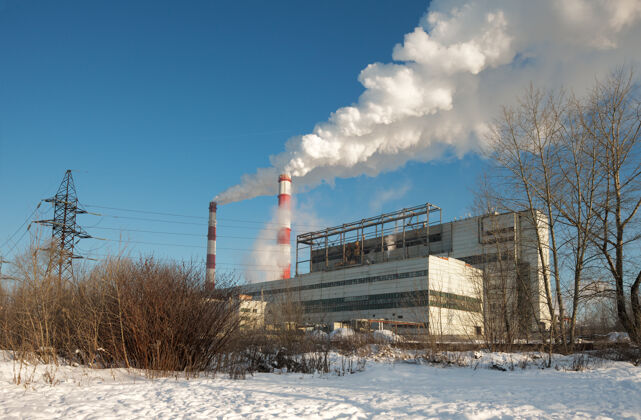 烟囱在一个寒冷的日子里可以看到发电厂的景色发电机霜冻煤气